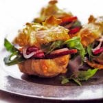 Gougeres, or cheese puffs, with arugula, bacon, and pickled onion on a metal plate