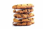 A stack of Neiman Marcus chocolate chip cookies separated by pieces of parchment.