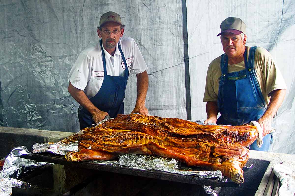 Ricky Parker positioning a slab of whole hog barbecue