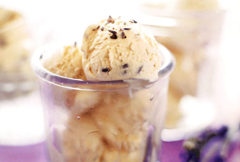 Glass of lavender honey ice cream, in a purple cloth with lavender sprigs