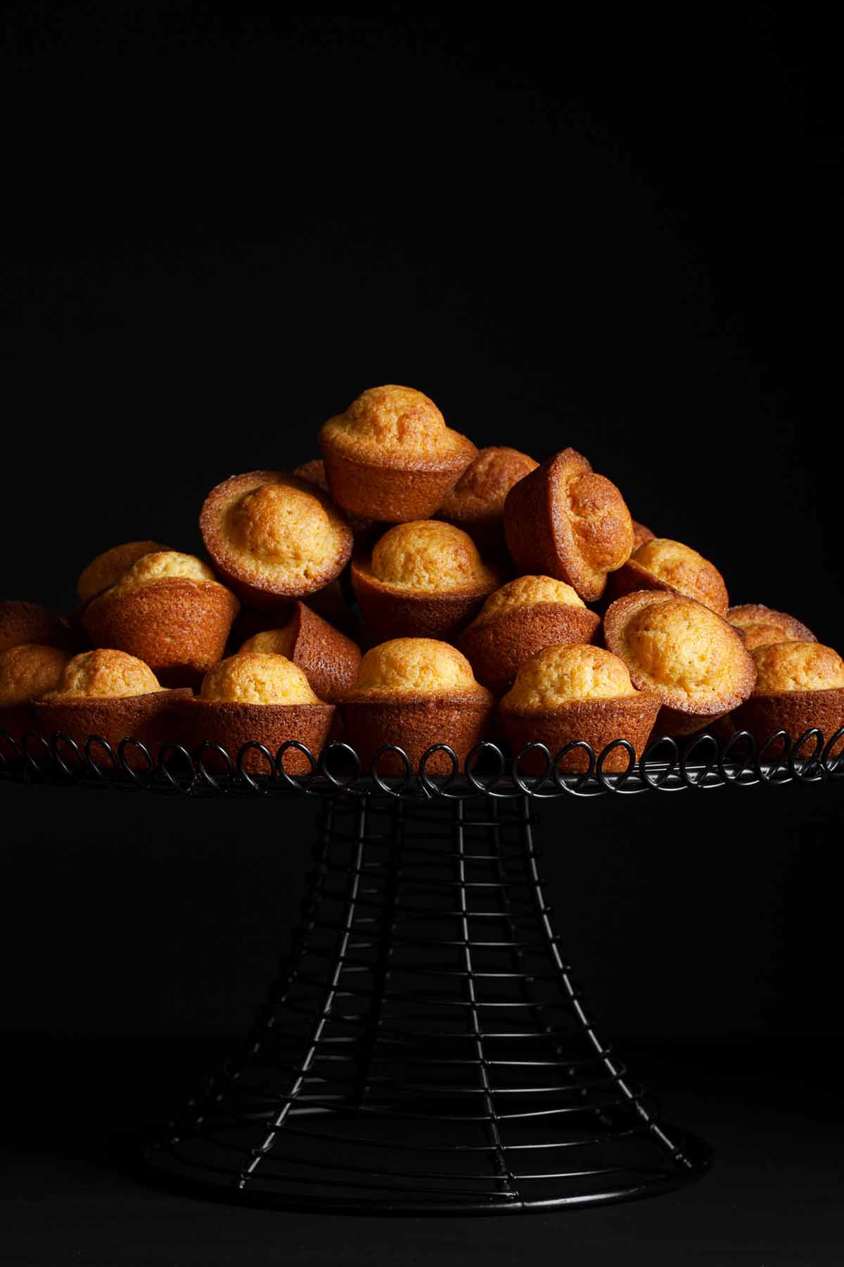 Portuguese mini lemon-orange cakes piled on a cake stand.