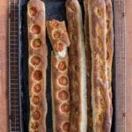 Five no-knead baguettes by Jim Lahey, some with sliced tomato, some with garlic and olives
