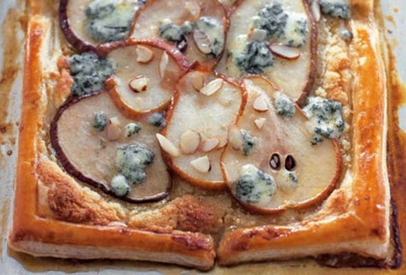 A pear tart with blue cheese and honey finished with sliced almonds.