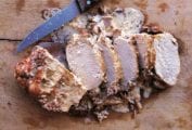 The classic Italian dish: roast pork cooked in milk sliced on a cutting board.