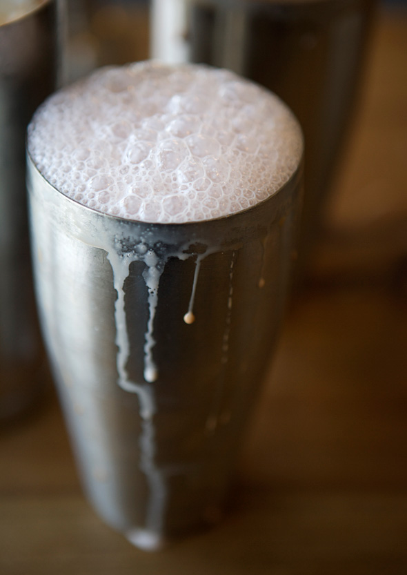 A metal shaker filled with egg cream.