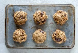 A cookie sheet with six breakfast cookies with oats, banana, figs, and peanut butter