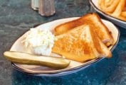 A classic grilled cheese sandwich--buttered grilled bread and oozing Cheddar cheese