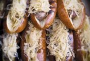 A stack of grilled beer braised bratwurst covered in sauerkraut.