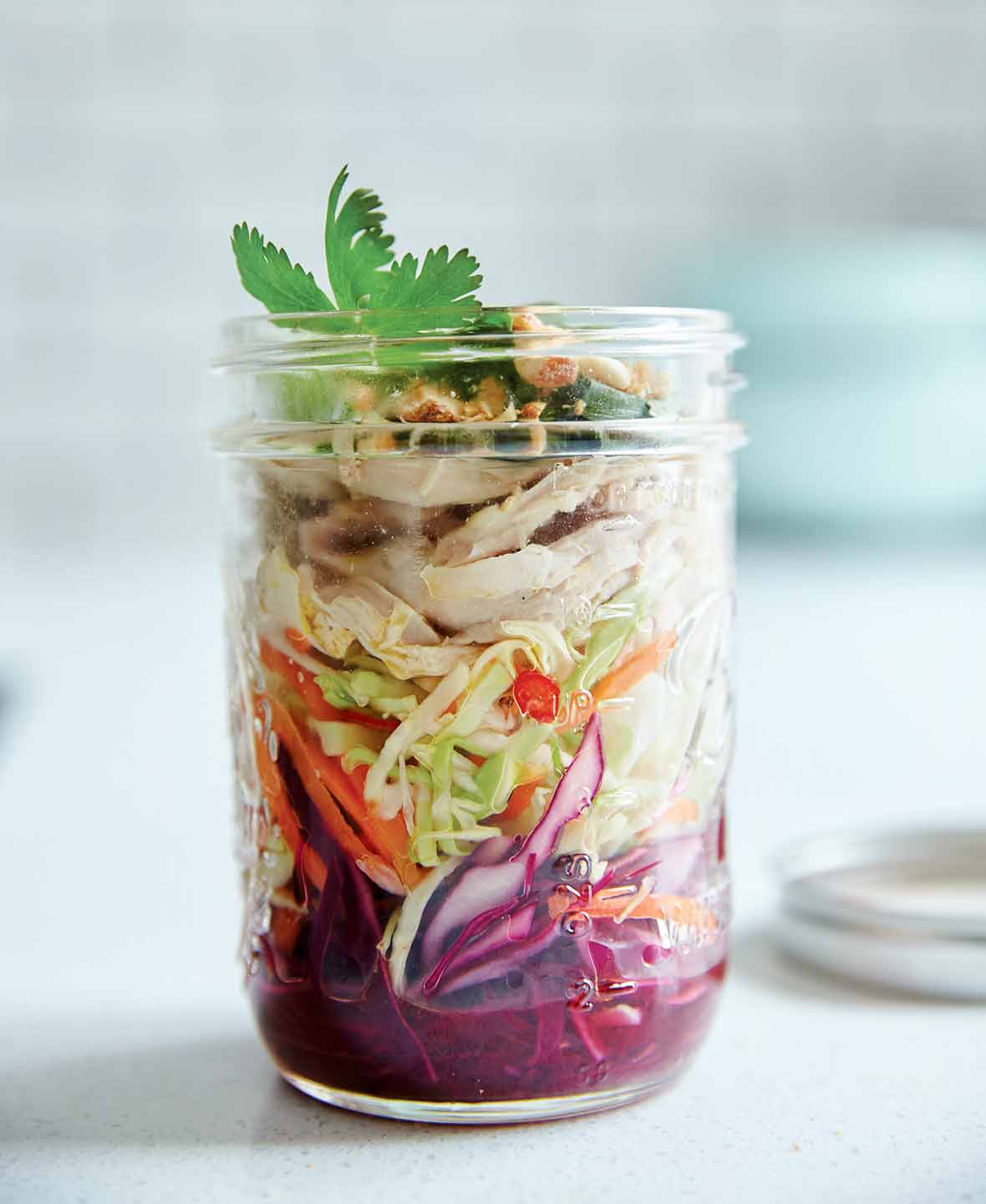 A glass jar filled with a layered Vietnamese chicken salad.
