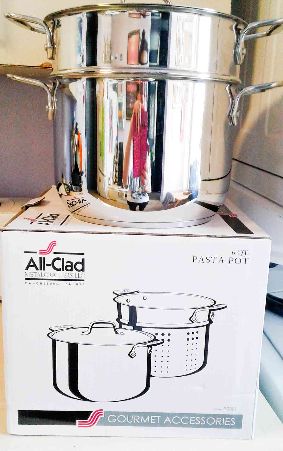 An All-Clad pasta pot sitting on its box