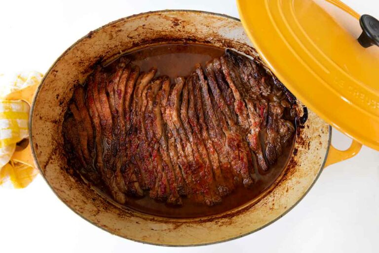 A yellow Le Creuset pot with Nach Waxman's sliced beef brisket inside