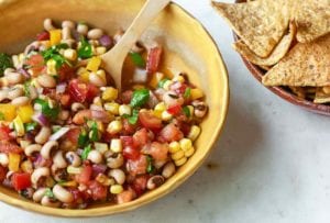 A yellow bowl of cowboy caviar--black-eyed peas, corn, red onion, tomato, red and yellow pepper by Dorie Greenspan