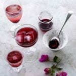 Several glass filled with purple Christmas hibiscus cocktail