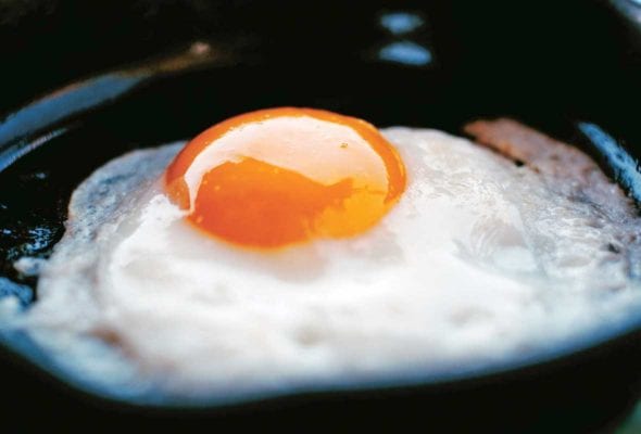 A perfect fried egg in a small black skillet.
