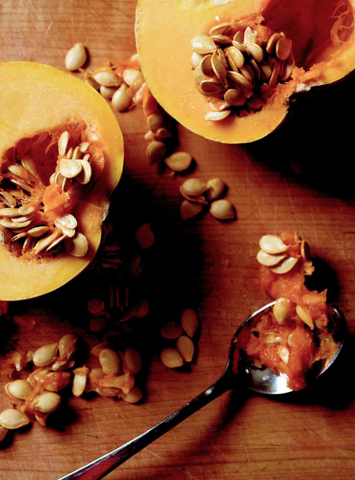 A halved butternut squash with the seeds partially scooped out to demonstrate how to waste less food.