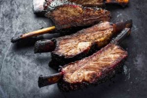A slab of barbecued beef back ribs cut into individual ribs.