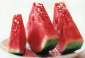 Three slices of watermelon with fleur de sel sprinkled over top.