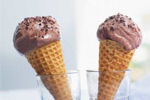 Two bitter chocolate and buttermilk ice cream cones in glasses.