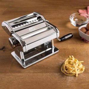 Marcato Atlas 10 Pasta Machine on wood counter with eggs and pasta nest.