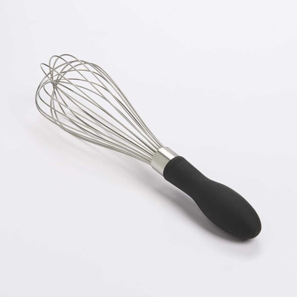 OXO Good Grips Balloon Whisk laying on white counter.