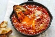 Spicy eggs in hell in a small cast-iron skillet, and half a piece of toasted bread.