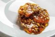 Three pieces of spicy pepita brittle on a white plate.