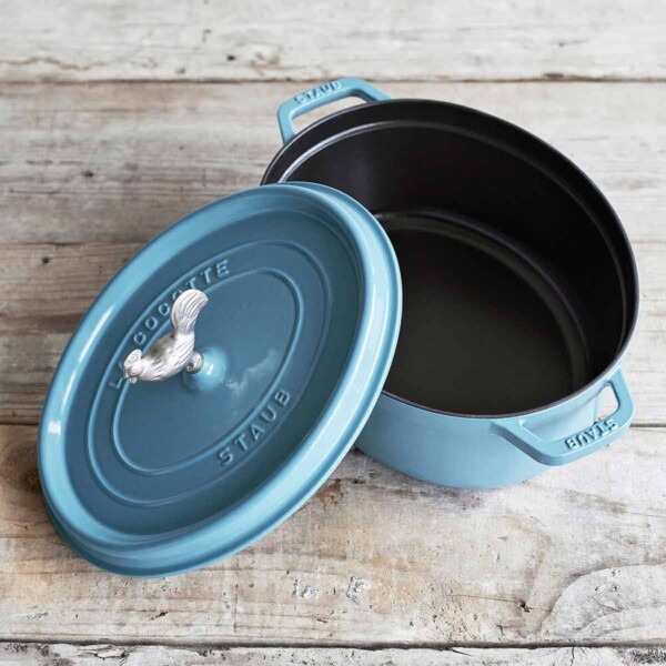 Staub Coq Au Vin Cocotte shown in blue with top askew.