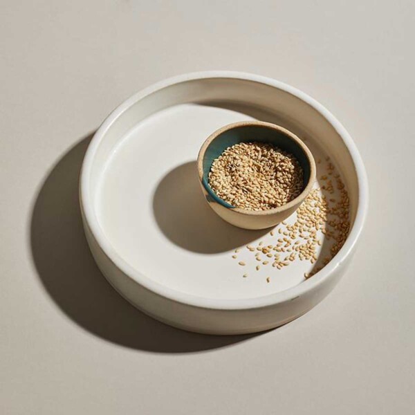 Toasted Sesame Seeds in small wooden bowl in large white bowl.