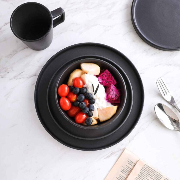 Black Stoneware Dinnerware featuring fruit salad in center bowl.