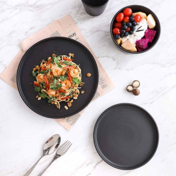 Black Stoneware Dinnerware shown with pad thai on plate and fruit salad in a bowl.