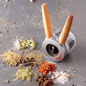 Dream Ortwo Spice Grinder surrounded on table by loose spices.