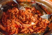 A fork in a pot of shredded Yucatan-style slow-roasted pork.