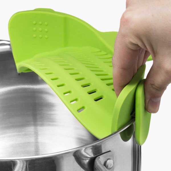 Clip-on strainer being attached to a saucepan.