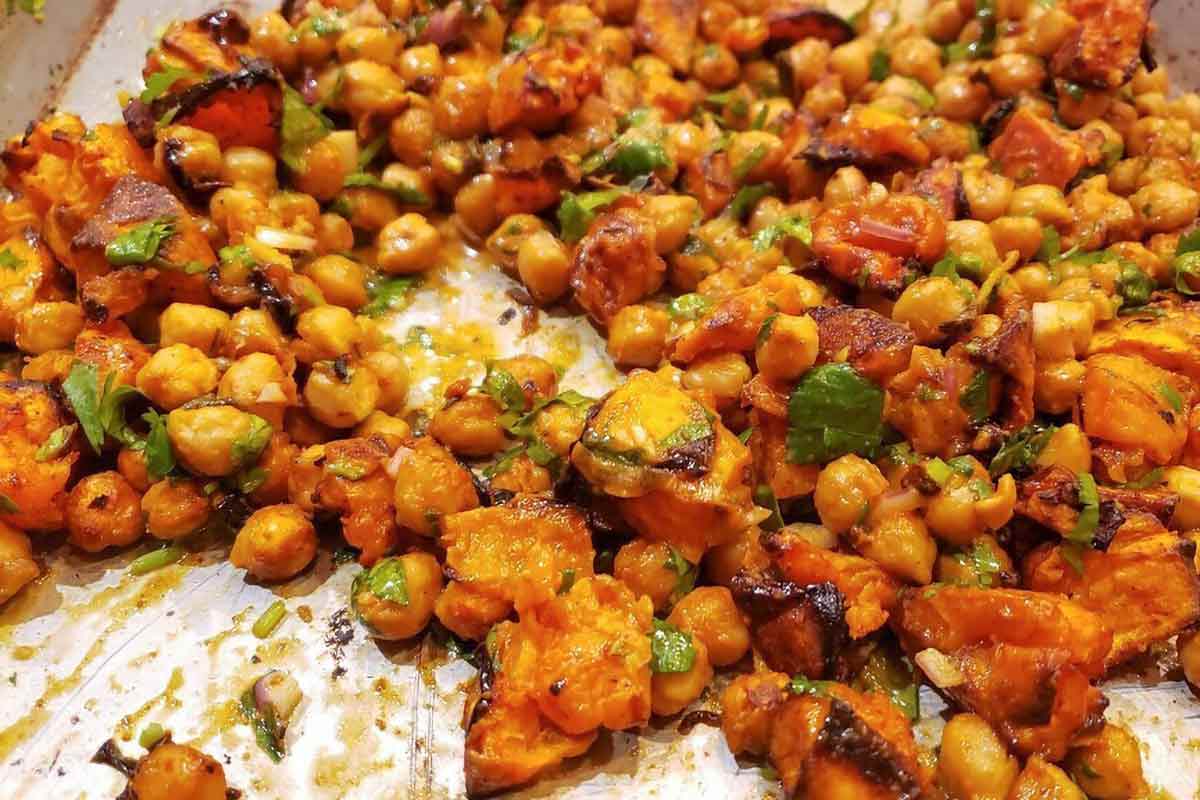 Roasted sweet potatoes and chickpeas on a rimmed sheet pan.