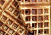A close view of cornmeal waffles overlapping each other.