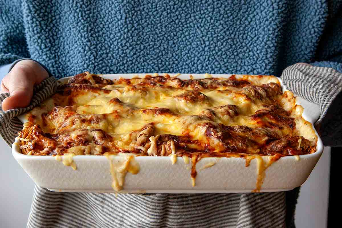 A person holding a finished croque monsieur casserole.