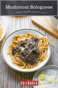 Three bowls filled with spaghetti and mushroom bolognese, next to a large pot of mushroom bolognese, and a small dish of Parmesan cheese.
