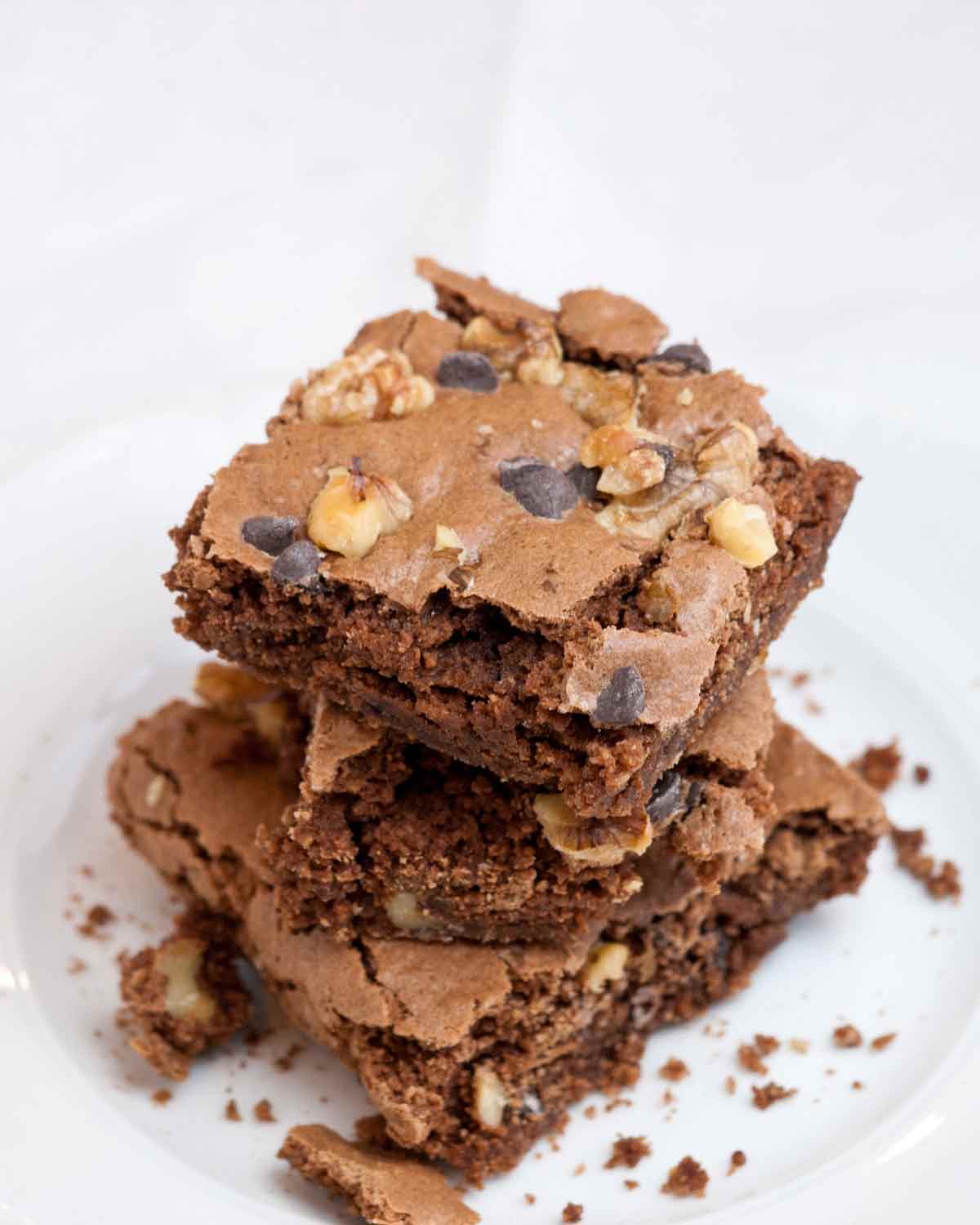 Three Passover brownies stacked on top of each other on a white plate.