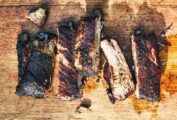Five cut Memphis style ribs on a wooden board.