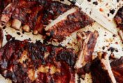 Two slabs of St. Louis style ribs from Alex Guarnaschelli with some cut into individual ribs and a knife lying in the middle.