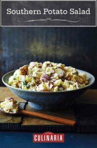 A bowl filled with Southern potato salad with a wooden spoon ad a scoop of salad on the side.