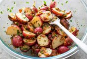 A bowl of German-style potato salad with a fork resting in it.