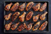 A tray with 18 grilled chicken wings with maple bourbon sauce.