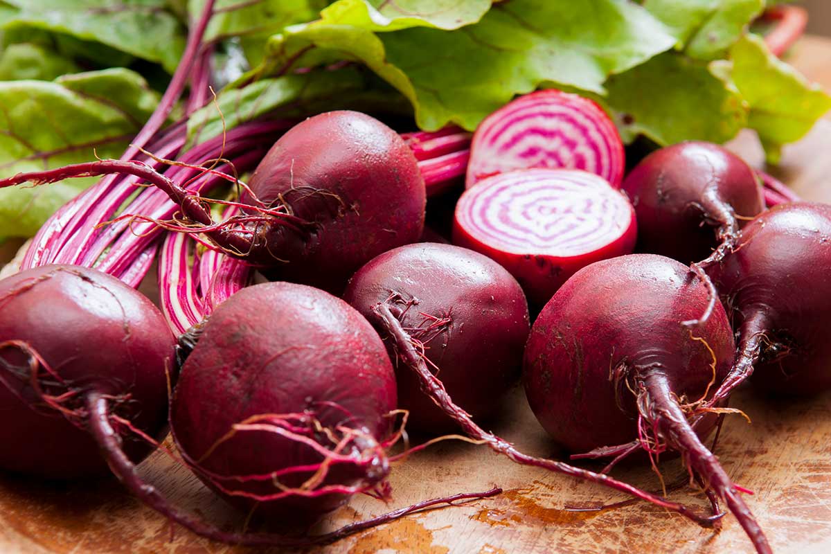 Bunches of chioggia beets on a cutting board.