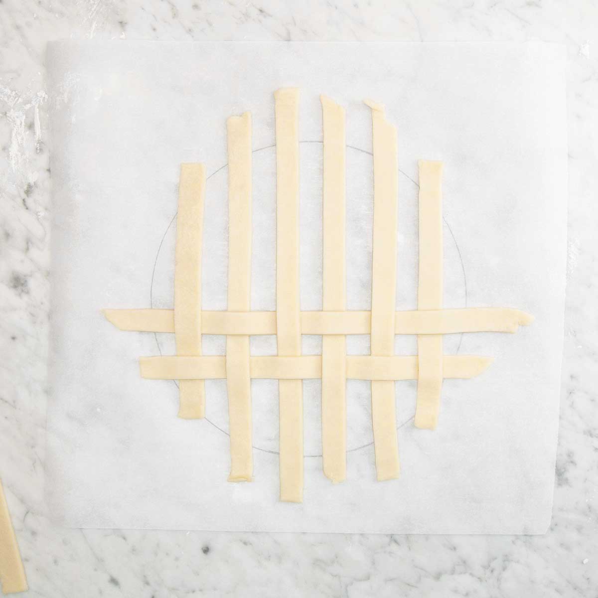 Strips of pie dough arranged in a lattice pattern.