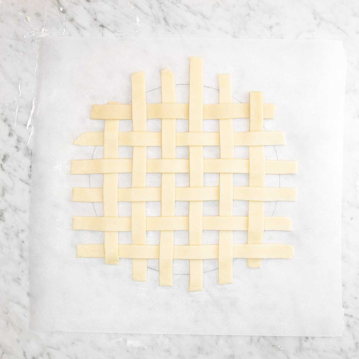 Strips of dough being arranged into a lattice pie crust.