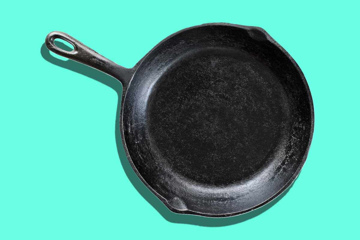 A nonstick skillet in response to the question 'is it safe to cook in a nonstick skillet?' on a blue background