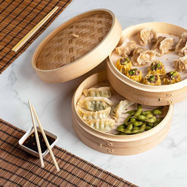 Bamboo Steamer Basket filled with edamame and dumplings.
