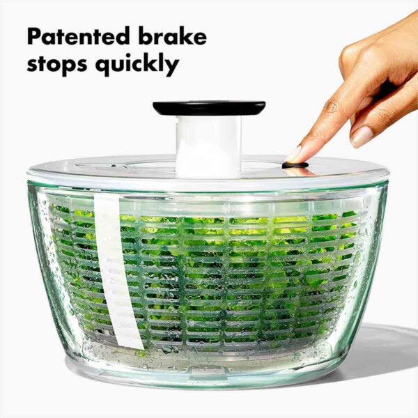 OXO Good Grips Glass Salad Spinner with finger on brake.