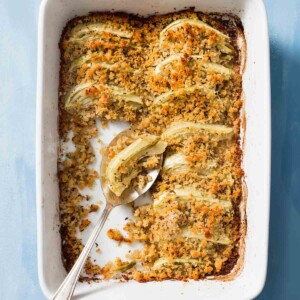 a white casserole dish of roasted fennel with rye crumble